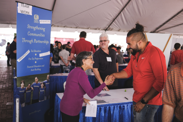 Volunteers shaking hands at the Portland volunteer expo.