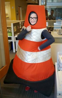 A woman dressed in an orange traffic cone costume.