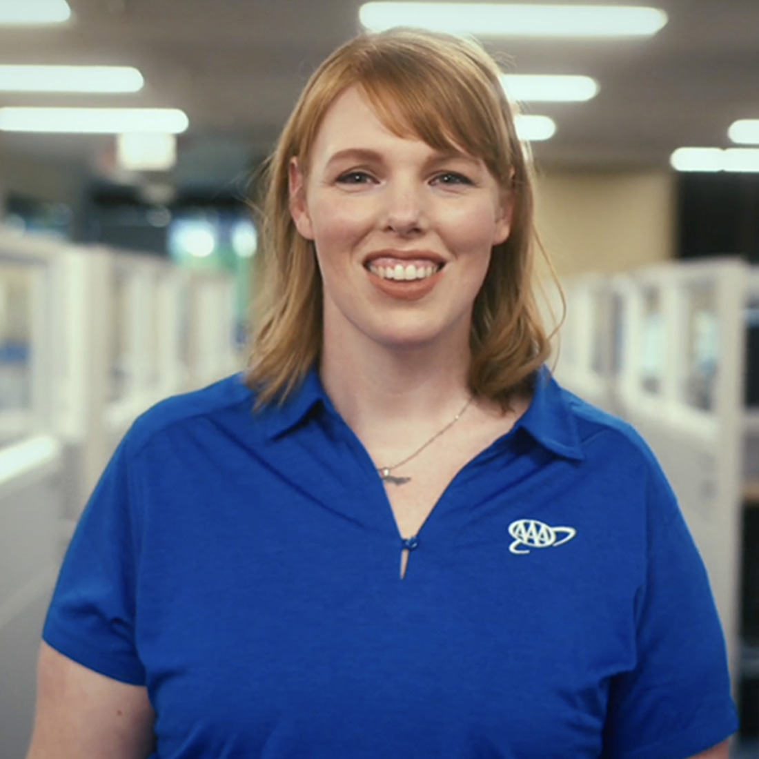 A headshot of a smiling young woman call center employee of AAA.