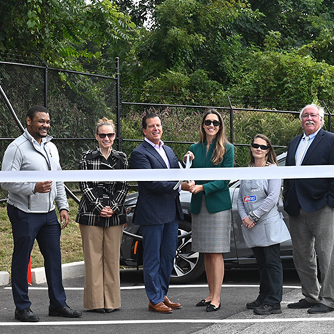 Eric Slifka, CEO of Global Partners and others perform a ribbon cutting ceremony as the City of Worcester, MA, celebrates the opening of new EV charging station.