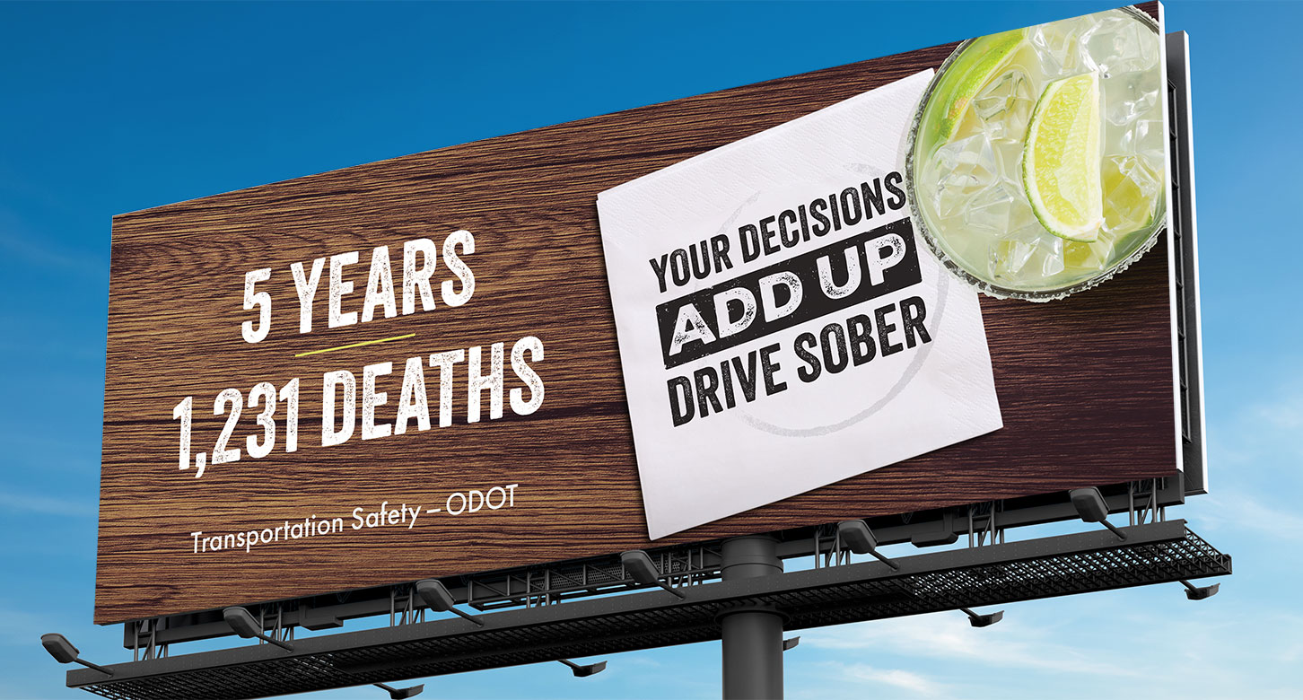 A billboard promoting ODOT's "Drive Sober" campaign with "Your decisions add up. Drive sober" printed on a cocktail napkin.