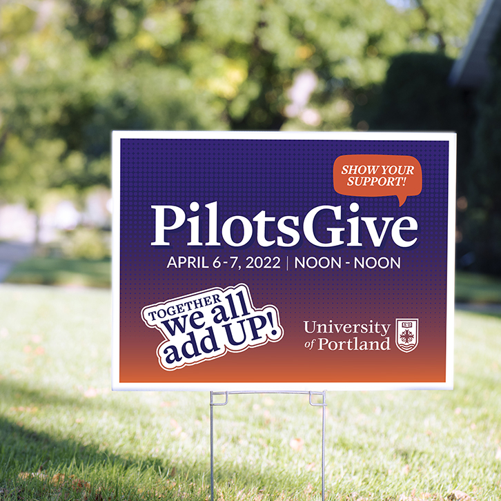 A lawn sign promoting the University of Portland's Pilots Give program.