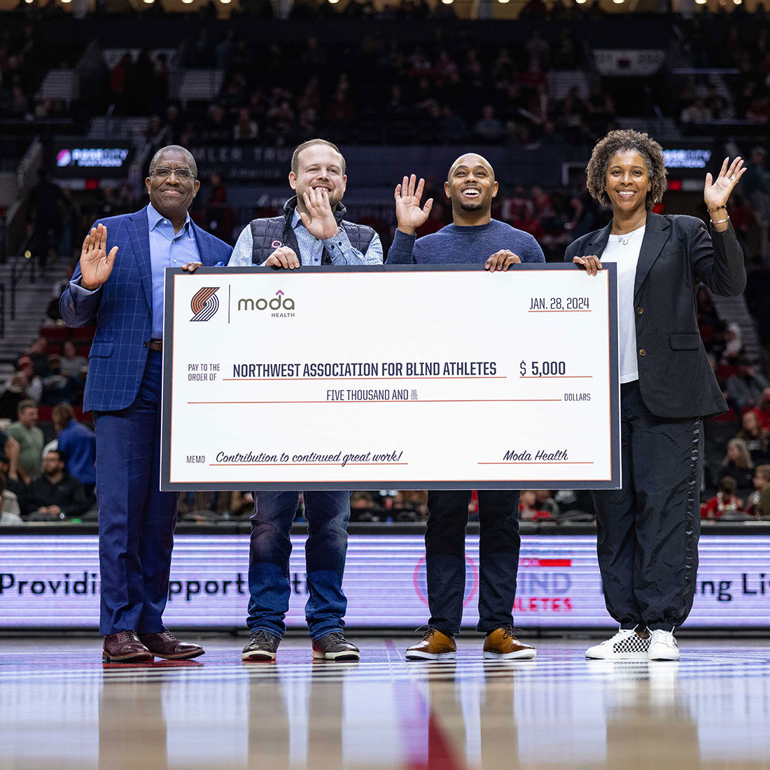 Officials from Moda hold a huge check symbolizing their gift to the Northwest Association for Blind Athletes.