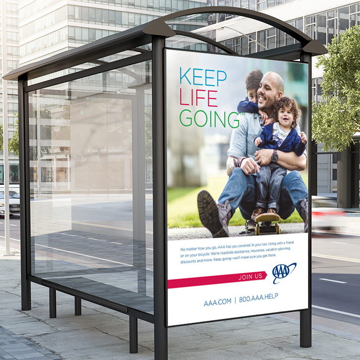 A bus shelter advertisement featuring the AAA "Keep Life Going" branding.