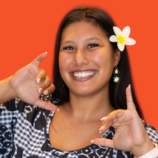 Mahina LaBoy smiling in a professional headshot with a flower in her hair.